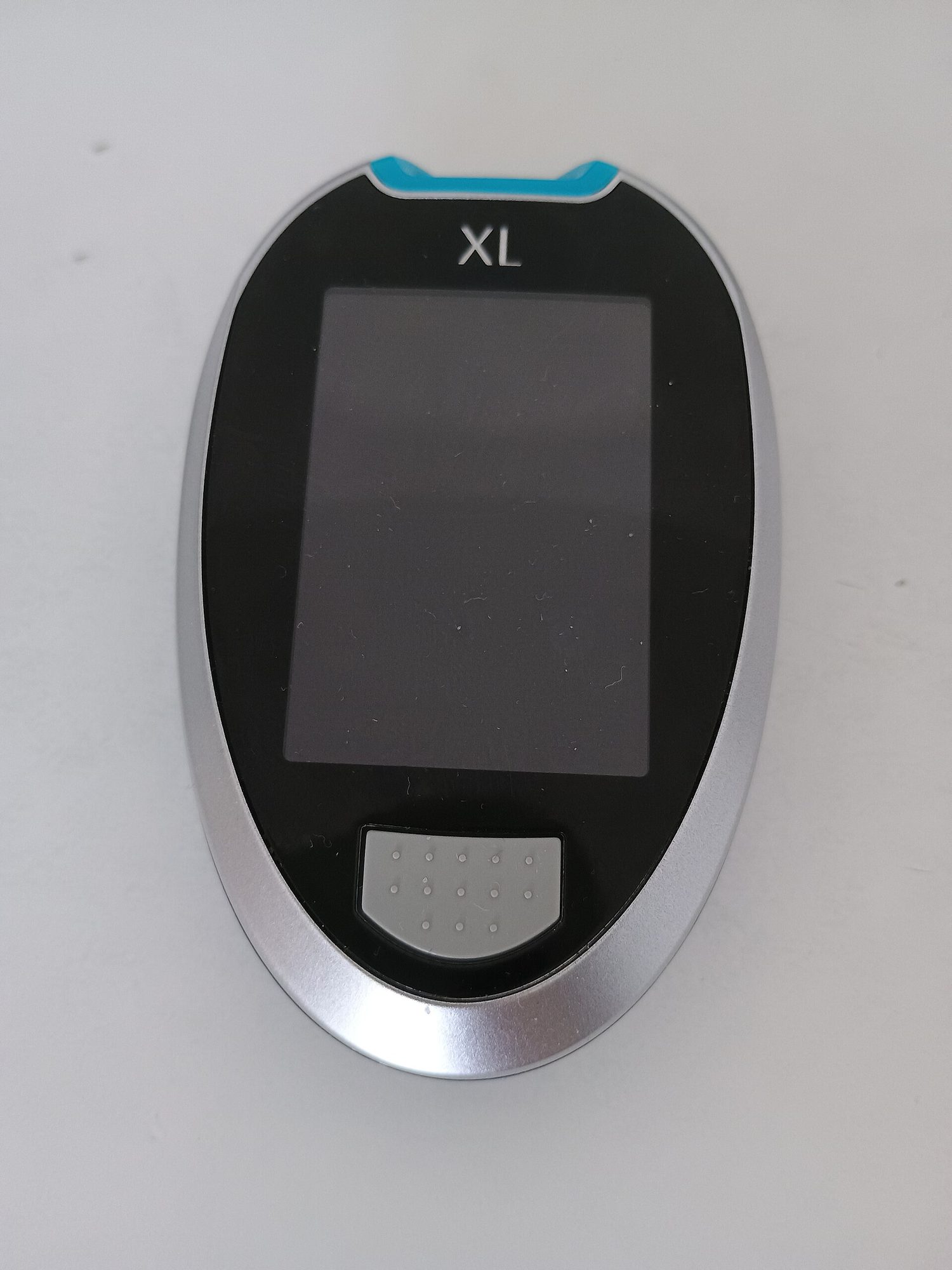 A handheld blood glucose meter showing a reading