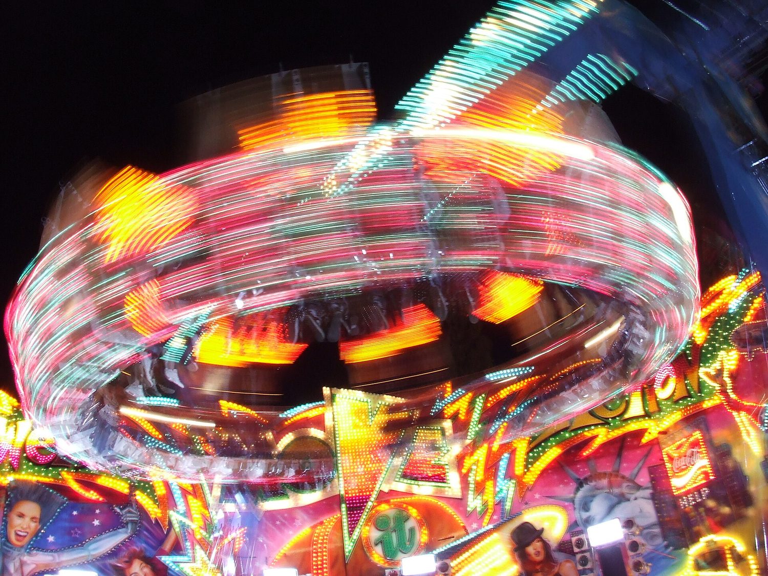 A spinning fairground ride lit up at night