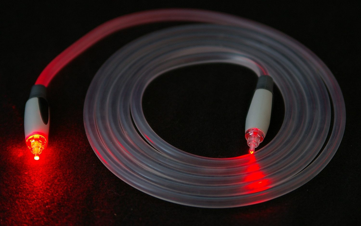 A cable opened up to show the thin glass fibres inside, with a ruler for scale
