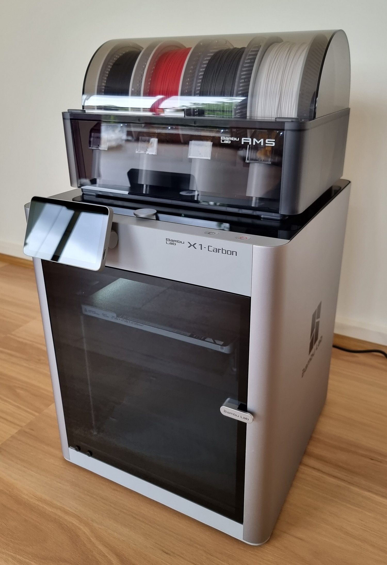 A 3D printer: a black metal frame holding a flat print bed and a moving print head
