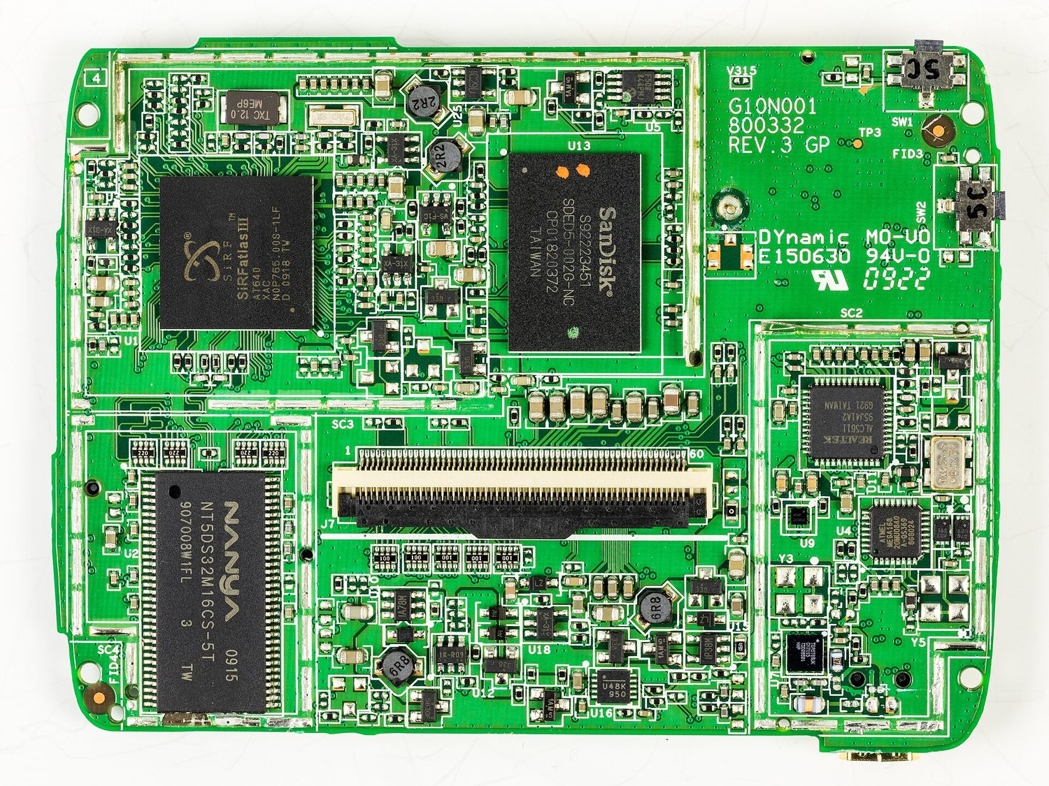 A green circuit board densely packed with chips, memory and connectors, taken from inside a satnav