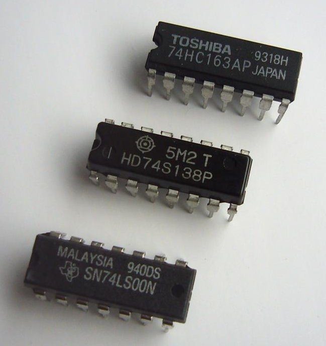 Three small black computer chips with rows of metal pins, each printed with a code