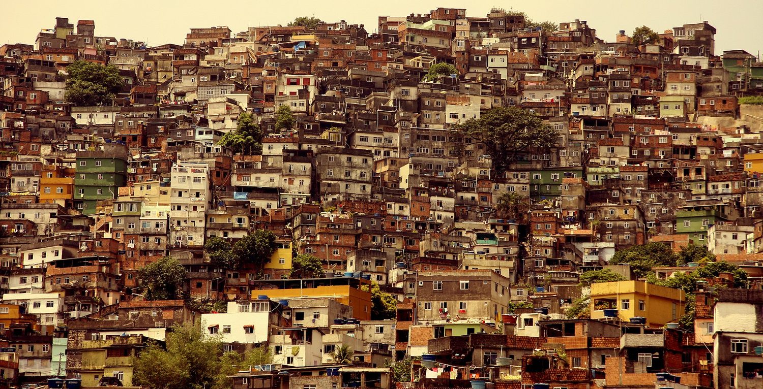 A hillside densely packed with the small houses of an informal settlement