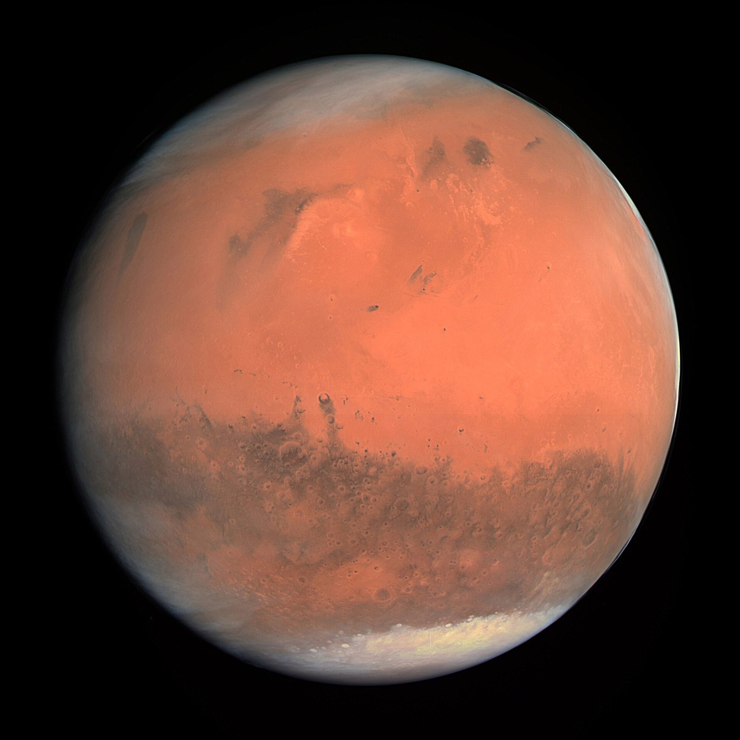 The full red disc of Mars against black space, with darker surface markings and a thin polar haze